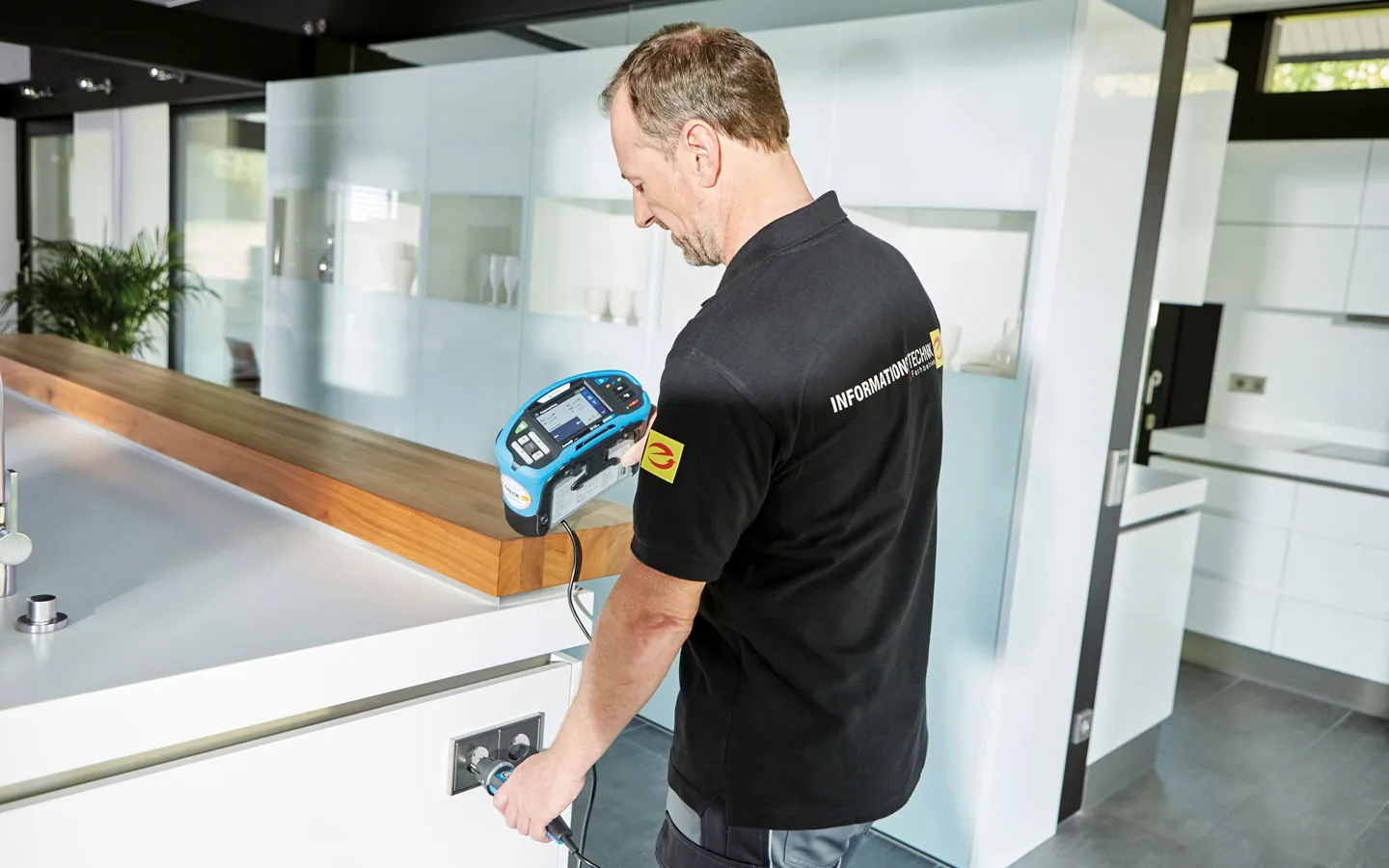 E-CHECK - Mitarbeiter prüft die Steckdosen in der Küche &middot; ABE Elektrotechnik