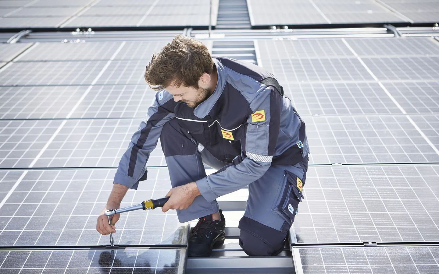 E-CHECK E-Mobilität - Mitarbeiter montiert auf dem Dach die neuen Solarmodule &middot; ABE Elektrotechnik